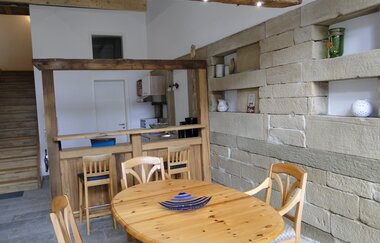Im Esszimmer steht ein Holztisch mit Stühlen vor einer rustikalen weiß gestrichenen Mauer | © Touristikgemeinschaft Hohenlohe e. V. | Familie Carle