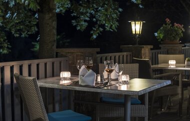 Außenterrasse am Abend mit Kerzen auf den Tischen | © Touristikgemeinschaft Hohenlohe e. V. | Die Krone am Fluss