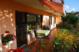 Terrasse der Ferienwohnung Abendsonne in Neckargemünd mit Sitzecke und vielen Blumen | © Ferienwohnung Abendsonne