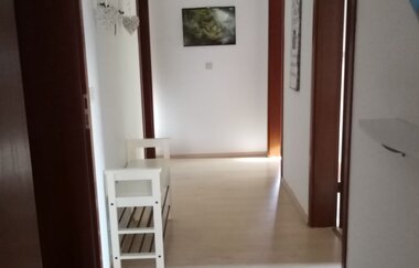 Flur mit vier Türen und einem kleinen niedrigen Schuhschrank