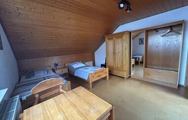 Blick in ein Schlafzimmer der Ferienwohnung mit zwei Betten, einem kleinen Tisch und Schränken | © Neckar-Zaber-Tourismus e.V.