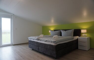 Zimmer in Terrassenlage, leichte Dachschräge, Doppelbett und zwei Nachttischschränkchen jeweils mit Lampe | © Neckar-Zaber-Tourismus e.V.