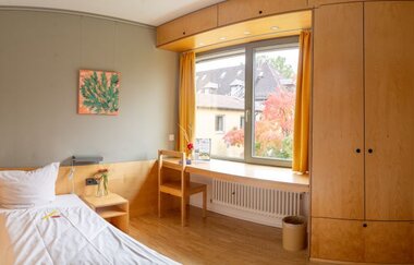 Einzelzimmer mit Bett und großem, hellem Fenster | © Touristikgemeinschaft Hohenlohe e. V. | Ländliche Heimvolkshochschule Hohebuch