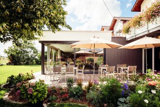 Frühstücksterrasse mit vielen Tischen und Stühlen und Schirmen | © Landpension Kohler