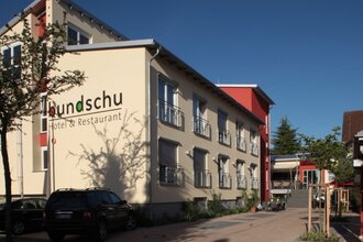 Außenansicht des Hotels und Restaurants Bundschu mit Parkplätzen und klarem Himmel | © Ringhotel Bundschu