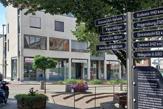 Ein Marktplatz in Gaildorf mit einem Wegweiser, der Entfernungen zu verschiedenen Städten und Ländern anzeigt. | © Petra Natzkowski