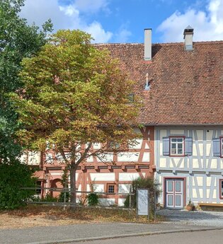 Fachwerkhaus in Gaildorf mit Bäumen im Vordergrund. | © Petra Natzkowski