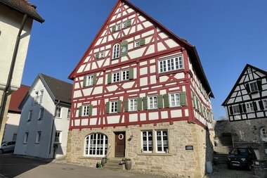 Café Fachwerk im liebevoll restaurierten Fachwerkhaus mit rot bemalten Balken und grünen Fensterläden | © Hohenlohe Schwäbisch Hall