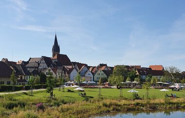 Landschaftsaufnahme vom Weiherpark Eppingen mit angrenzender Wiese und Spielplatz. Im Hintergrund die Stadtsilhoutte der Fachwerkstadt Eppingen. | © Stadt Eppingen