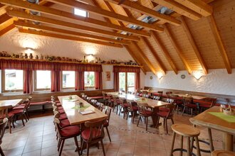 Die Besenwirtschaft ist rustikal mit Tischen und Stühlen eingerichtet. Die Decke hat helle Balken. | © Touristikgemeinschaft Hohenlohe e. V.