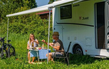 Ein Paar frühstückt vor dem Wohnmobil | © Touristikgemeinschaft Hohenlohe e.V. | Dominik Rau