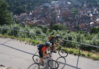 Radler fahren auf einem Weg oberhalb einer Stadt | © Jürgen Eck