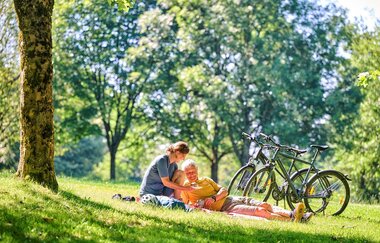 Radfahrer machen Picknick auf der Wiese | © Touristikgemeinschaft Hohenlohe e. V. | Florian Trykowski