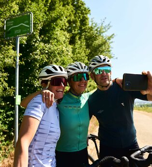 Drei Gravelbiker machen ein Selfie auf einer Tour durch die Weinberge im Land der 1000 Hügel. | © Tourimia Tourismus GmbH | Stefan Leitner Photography