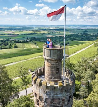Zwei Personen genießen den Ausblick vom Aussichtsturm Heuchelberger Warte. | © Touristikgemeinschaft HeilbronnerLand