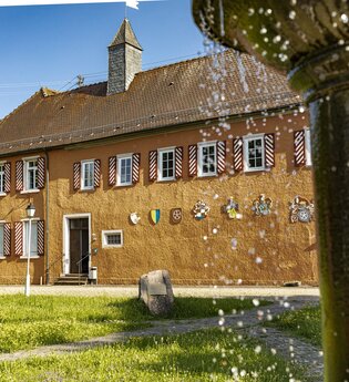 Wasserschloss Großeicholzheim mit Wiese und plätscherndem Brunnen im Vordergrund | © Touristikgemeinschaft Odenwald e.V.